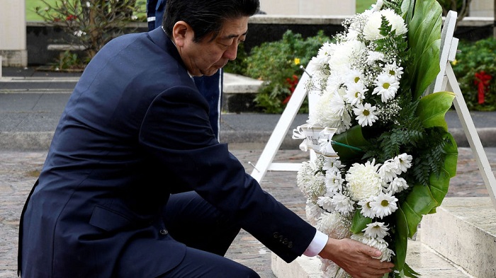 Japan PM Shinzo Abe lays wreaths in Hawaii ahead of Pearl Harbor visit